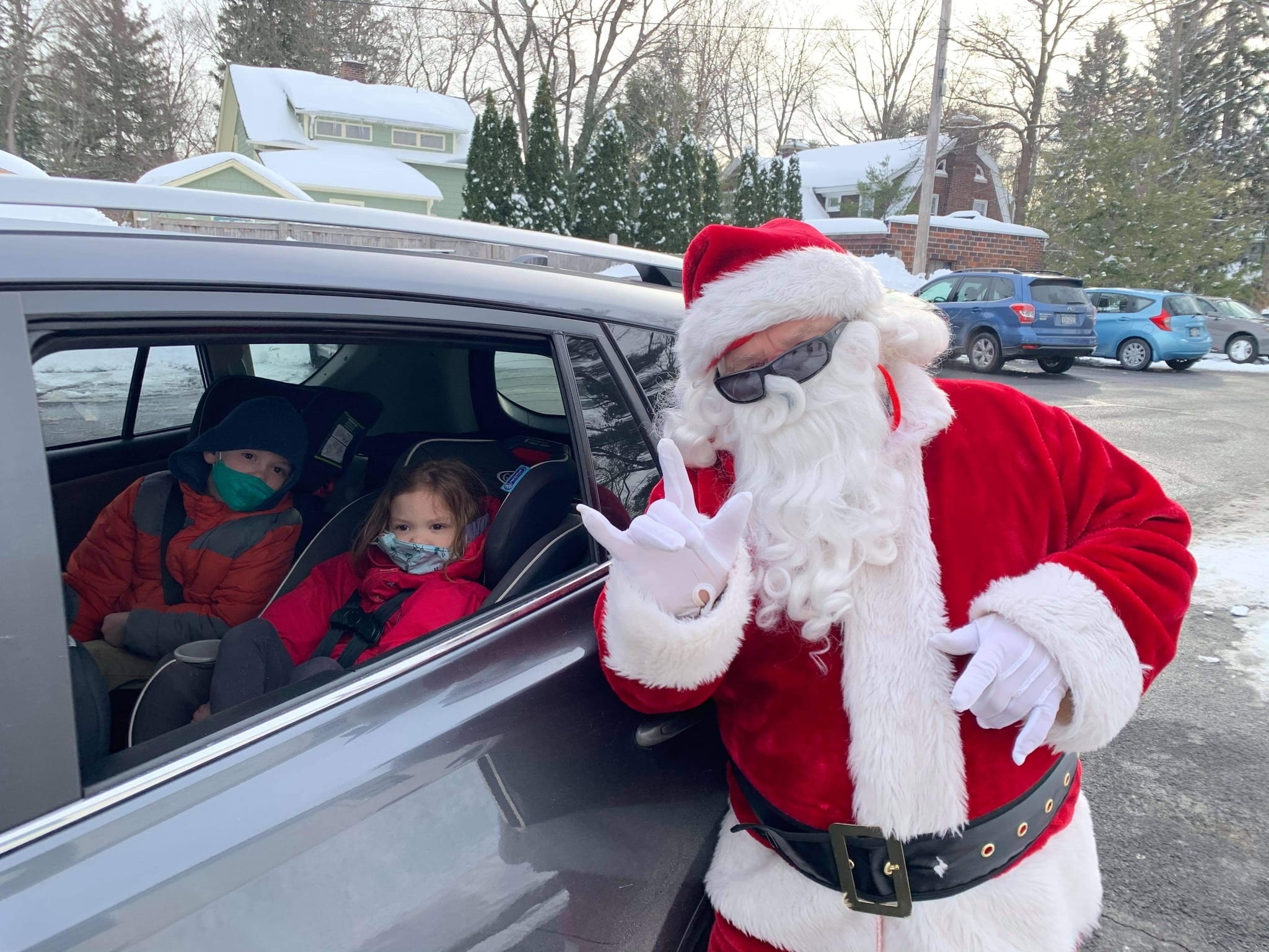 Santa greeting with kid in the car.