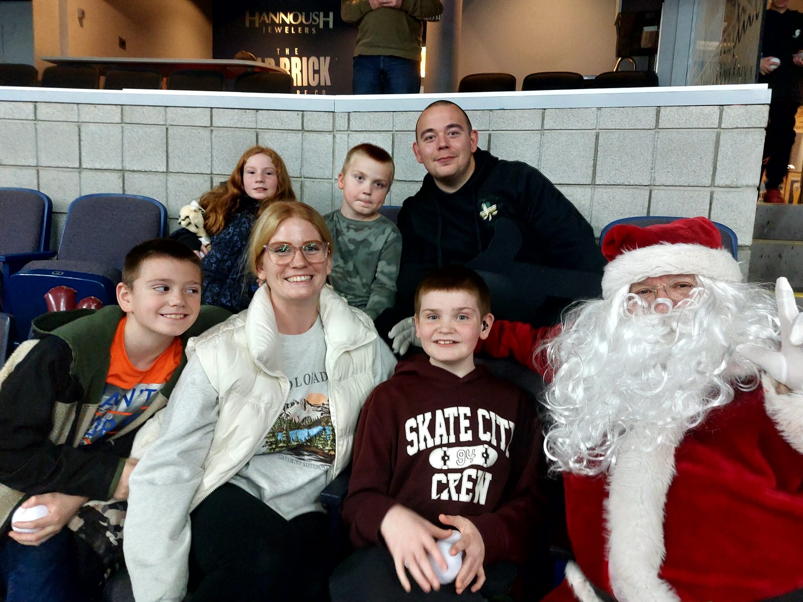 Family posing with Santa at Lacrosse game.
