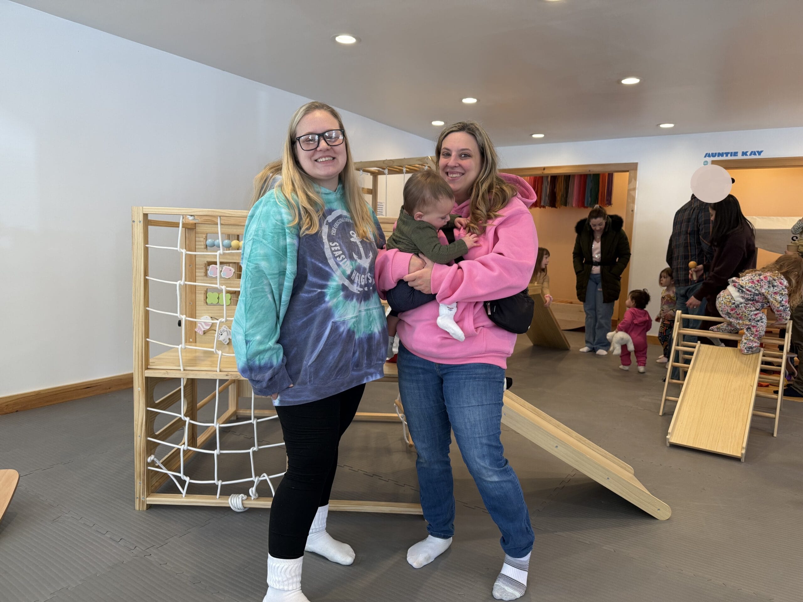 Image of two women smiling with a child