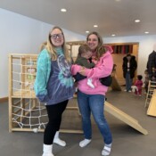 Image of two women smiling with a child